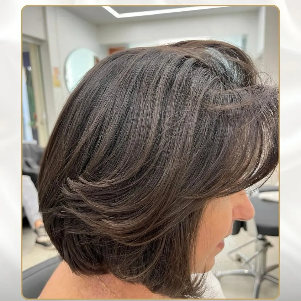 Corte bob com camadas, cliente de perfil, salão com espelho redondo